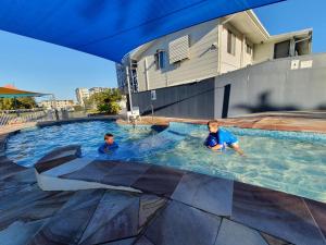 亚历山德拉岬角亚历克斯海滩小屋和观光园酒店的两个男孩在游泳池游泳