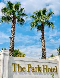 图兹拉伊斯坦布尔公园酒店的公园酒店标志后面两棵棕榈树