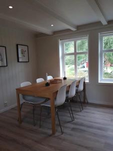 艾菲约德An authentic experience in picturesque Eidfjord的一间带木桌和白色椅子的用餐室