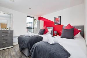 曼彻斯特Stylish 2 Bed Apartment with Free parking, close to City Centre by Hass Haus的卧室设有两张床铺和红色的墙壁