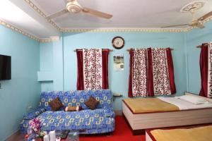加尔各答Hotel Airways的一间卧室配有一张床、一张沙发和一个时钟