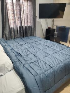 Trincity Preferred Place的卧室的床上的蓝色被子