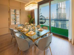 迪拜FIRST CLASS 3BR with full BURJ KHALIFA and FOUNTAIN VIEW的一间带桌椅和大窗户的用餐室