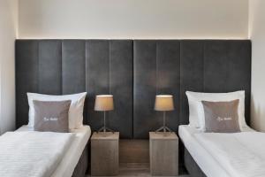 NeutalRestaurant & Hotel Dabuki的配有两盏灯的房间的两张床
