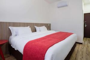 奥萨斯库Ramada Encore by Wyndham São Paulo Osasco的一间卧室配有一张带红色毯子的大床