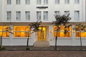 诺德奈乐格瑞和斯奥斯特尼非茶酒店的白色的建筑,窗户上设有黄色的灯光