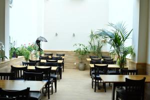 美因河畔法兰克福 慕尼黑霍夫酒店的餐厅设有木桌和椅子,种有植物