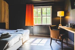 瓦夫尔多迈纳杜布鲁酒店的一间卧室配有一张床、一张书桌和一个窗户。