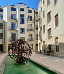 罗兹Apartament Green - Piotrkowska 37的建筑前的游泳池中的雕塑