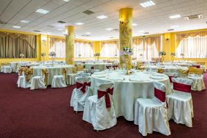 塔古玖Motel Dasiana的宴会厅配有白色的桌椅和弓形