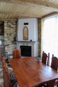 亚列姆切Cottage "Karpatske Shale"的一间带木桌和壁炉的用餐室