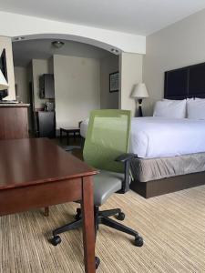 海恩斯维尔海恩斯维尔快捷假日&套房酒店的酒店客房配有一张床、一张桌子和一把椅子。