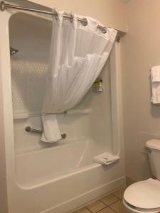 海恩斯维尔海恩斯维尔快捷假日&套房酒店的浴室配有白色浴缸和卫生间。