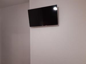 奥利瓦橙花酒店的挂在墙上的平面电视