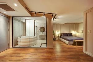 伊斯坦布尔Concept Nisantasi Hotels & Spa的一间带浴缸的浴室和一张位于客房内的床
