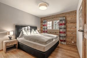 阿罗萨Alpslodge - Amelia的一间卧室设有一张大床和木墙