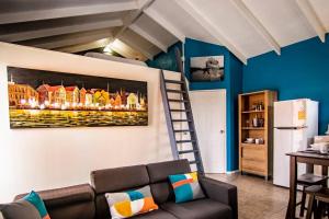 威廉斯塔德CityLife Apartments in historic Willemstad - 2 bedroom apartment with attic - O的客厅配有沙发和墙上的绘画