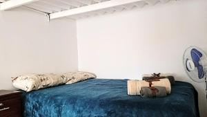 萨利纳斯Dulcinea Mini House的一间卧室配有一张带蓝色毯子的床