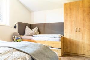 萨菲登安斯泰内嫩米尔Ferienwohnung Kracherbauer的一间卧室设有两张床和木制橱柜