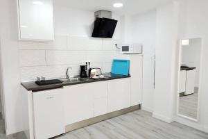 大加那利岛拉斯帕尔马斯Precioso apartamento a 150 metros de la Playa的白色的厨房配有水槽和微波炉