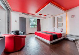 Las ÁnimasHotel Puente Grande的红色卧室配有床和椅子
