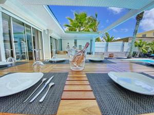 东方湾Villa Zandoli, walkable Orient Bay beach, private pool的一张餐桌,上面有白板和银器