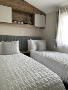SwarlandLazy Bear Lodge Northumberland的一间卧室设有两张床和窗户。