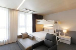 昌原市Grand City Hotel Changwon的一间卧室配有双层床和椅子