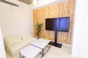 藤泽AQA ART 江の島的客厅配有沙发和墙上的电视