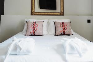 里摩日Maison Durieux的一张带两个枕头的白色床和白色袜子
