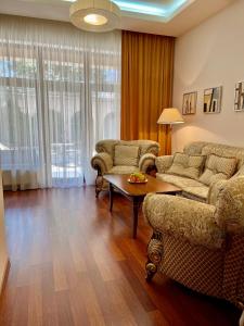 敖德萨阿卡达公寓酒店的客厅配有两张沙发和一张桌子