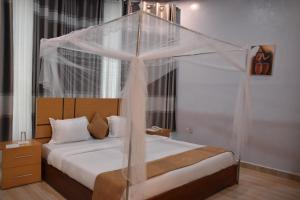 RwumbaChimpanzee Lodge的一间卧室配有一张带天蓬的床