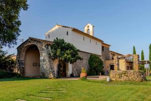 TonyaErmita de Santa Llúcia Casa rural histórica的一座大型石头建筑,在院子里设有教堂