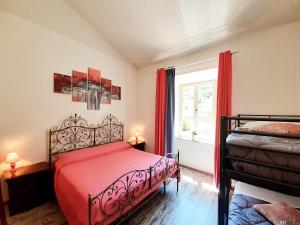 奇维塔韦基亚DIMORA IL CAMALEONTE, apartments in nature near the sea的一间卧室设有红色的床和窗户。
