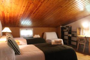 蒙塞尼欧德雷格旅馆的一间卧室设有两张床和木制天花板