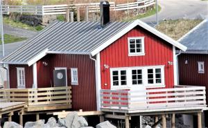 雷讷Andøy Vest Rorbuer Reine的码头上一些岩石旁的红色房子