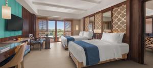 邦劳阿罗纳海滩赫纳度假村的酒店客房配有两张床和一张书桌