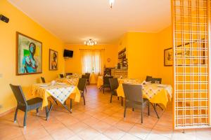 圣塔·马里亚·迪·帕尔玛Bonsai B&B Alghero的用餐室设有桌椅和黄色的墙壁