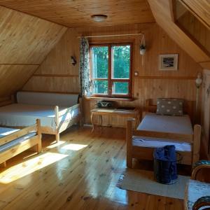 GibyPod Dębem的一间设有两张床的房间和一个位于小屋的窗户