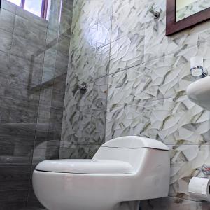 塔巴贝拉基多拉斯梅塞德斯机场酒店的浴室配有白色卫生间和淋浴。