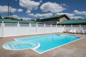 加纳诺克豪生加纳诺克酒店的一个带白色围栏的庭院内的游泳池