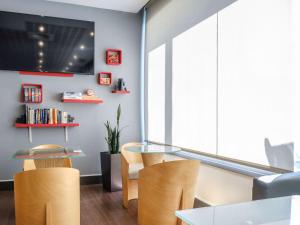阿尔考本达斯宜必思马德里阿尔克贝达斯酒店的一间设有玻璃桌和椅子的用餐室