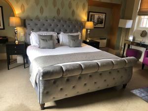 林肯The Lincoln Hotel的一间卧室配有一张大床和软垫床头板