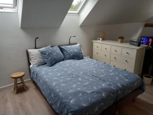 BeilenBed & Breakfast Beilerhorst的一间卧室配有一张带蓝色床单的床和梳妆台。