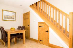 比尔伯勒Piper Cottage, Bilbrough, York的一间带木桌和楼梯的用餐室