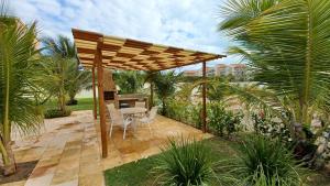 阿奎拉兹Palm Beach, Porto das Dunas的一个带桌椅的木制凉棚天井