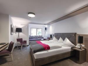 圣安东阿尔贝格Quality Hosts Arlberg - Hotel Goldenes Kreuz B&B的一间带大床的卧室和一间客厅