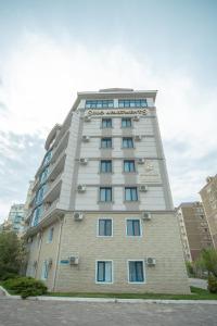 阿特劳SULO Apartments的一座高大的白色建筑,设有蓝色的窗户