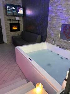 泰拉奇纳Sweetlove Spa的带壁炉的客厅设有大浴缸。