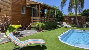 圣弗朗索瓦Villa Rosa Karibella的一个带游泳池、椅子和房子的庭院